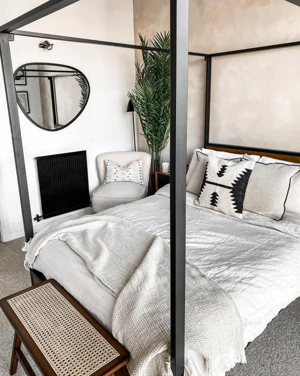 Small Bedroom with Black Frame Canopy Bed and Wall Mirror