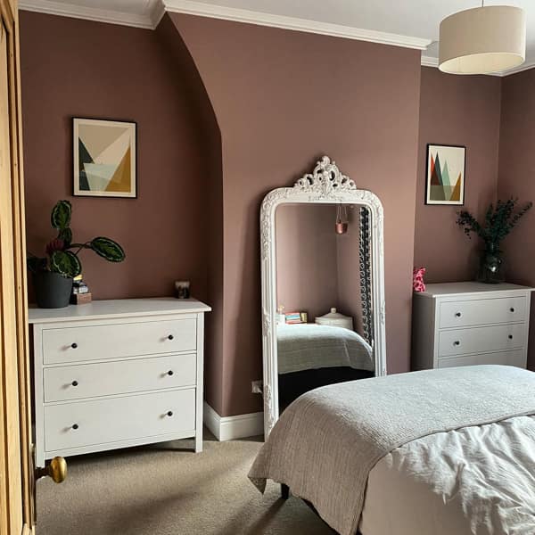 White Furniture and Mirror Against Darker Walls in Bedroom